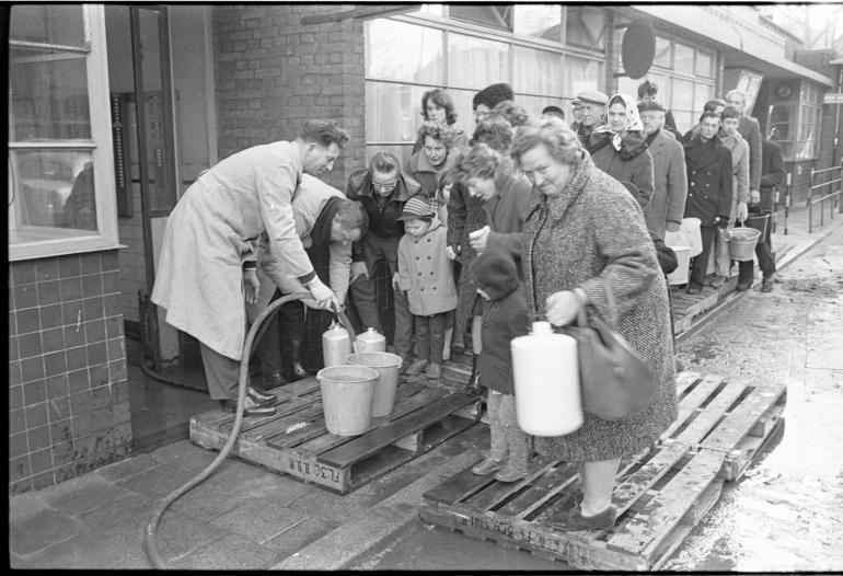 Mensen halen drinkwater bij een distributiepunt